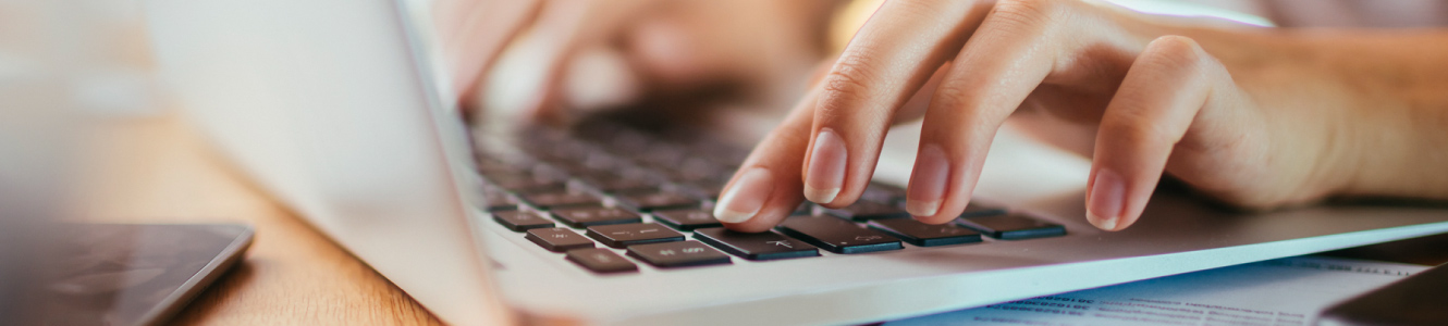 hands typing on computer.