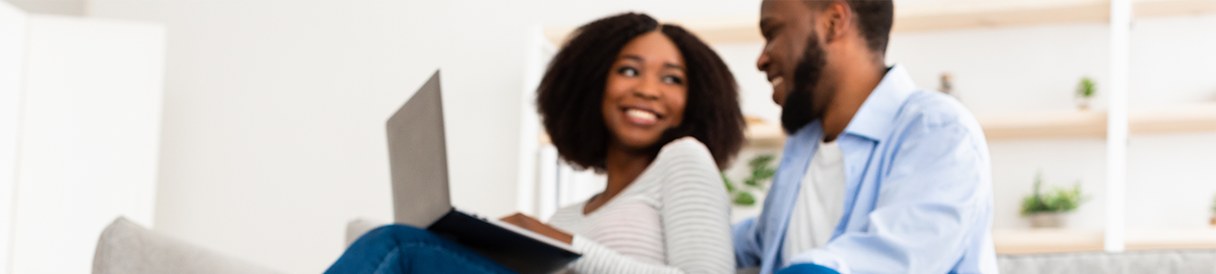 Young couple looking at a laptop together, soft-focused.