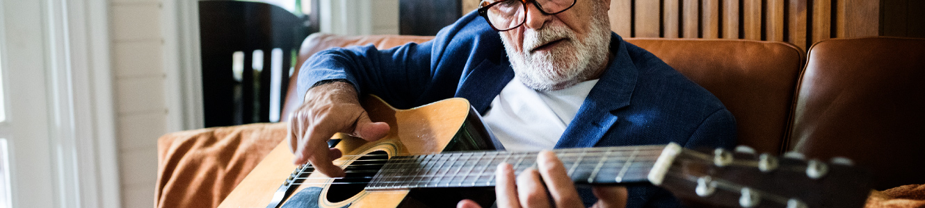 mature man playing guitar.