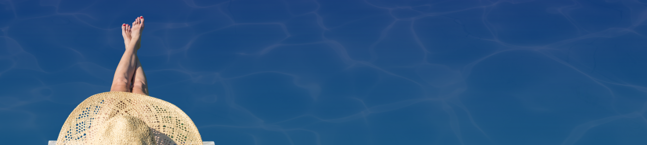 A woman wearing a hat sitting with legs in the pool.